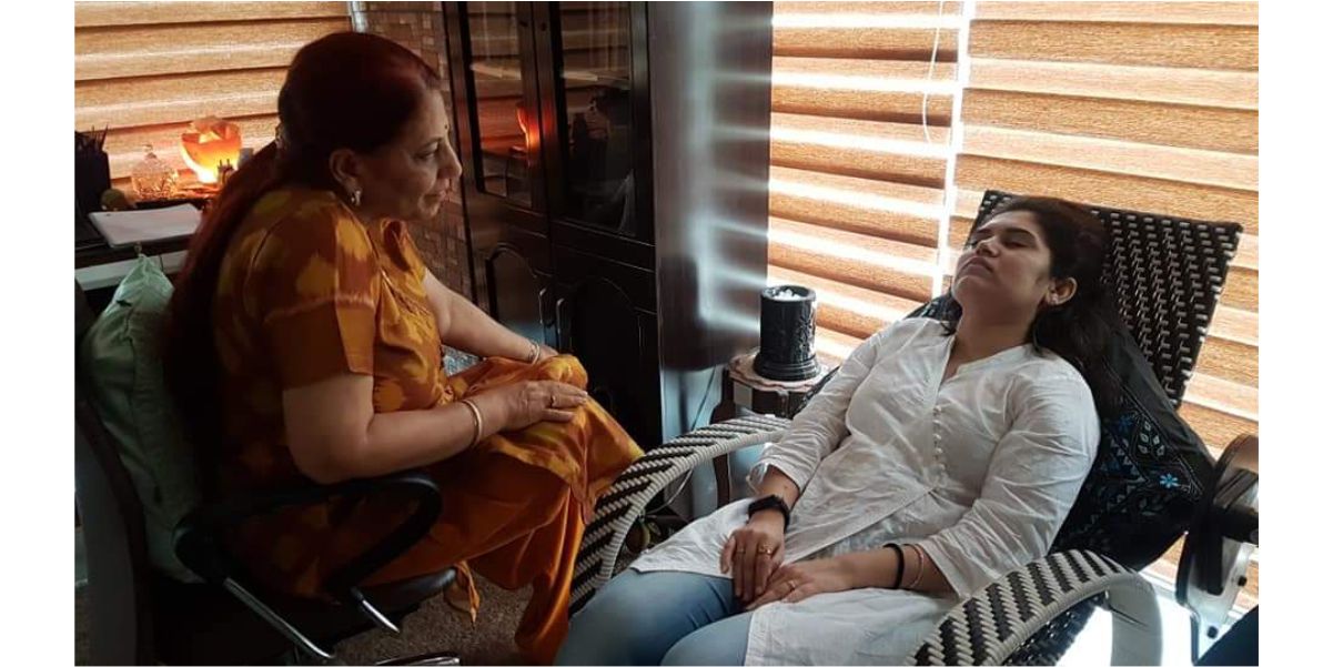 A hypnotherapy session at SFCT: a practitioner sits beside a client reclining with eyes closed in a relaxed, guided state.