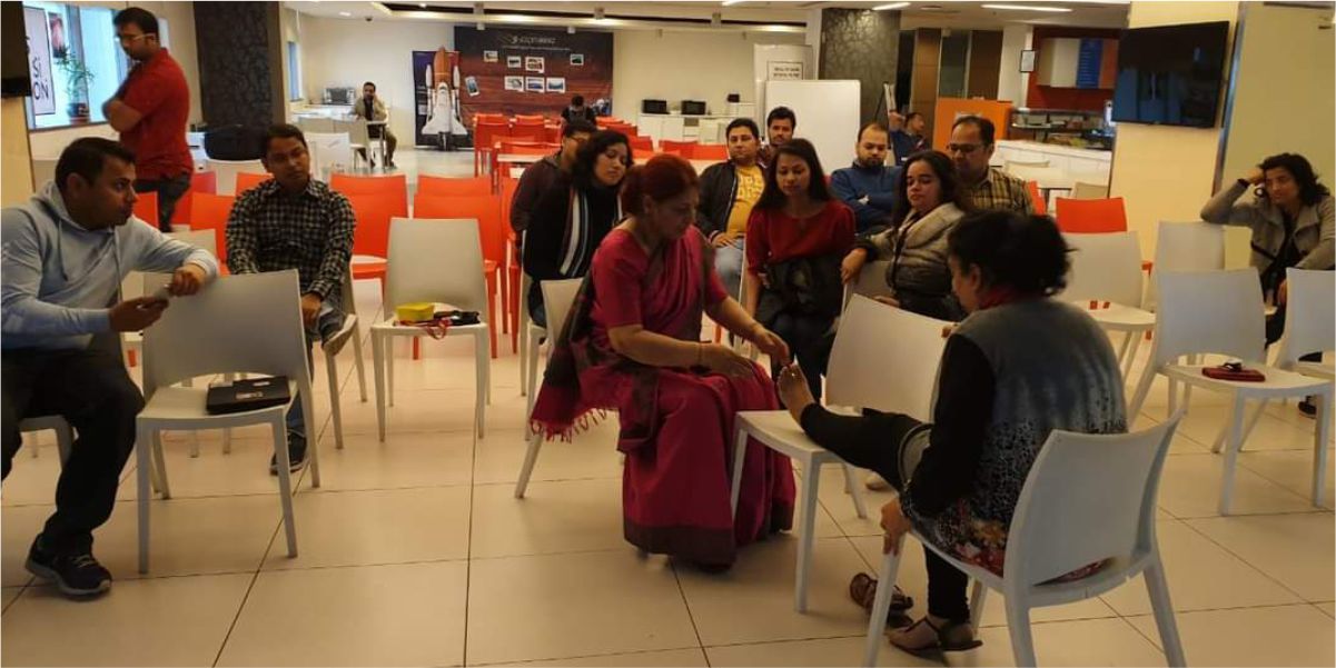 A foot reflexology workshop at SFCT: a practitioner demonstrating technique to a seated group in a training session.