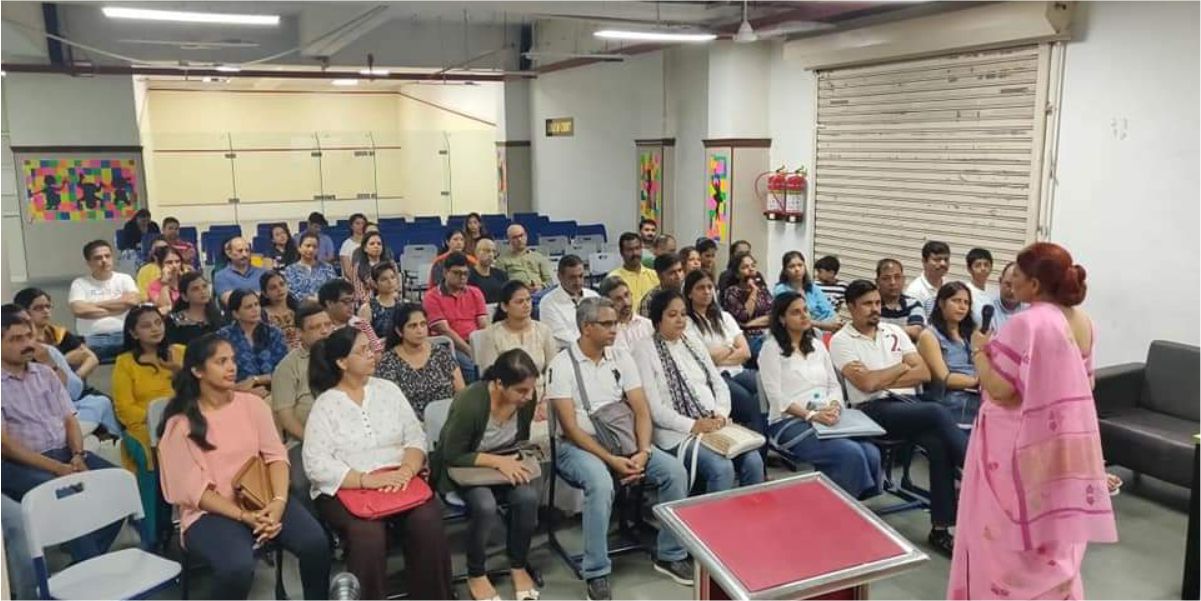 A soft skills training session at SFCT: a facilitator addresses a seated group of adult participants in a training hall.